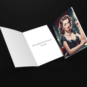 May include: A greeting card with a woman in a black dress and a red background. The text on the card reads "The only thing I'm stirring up is trouble."