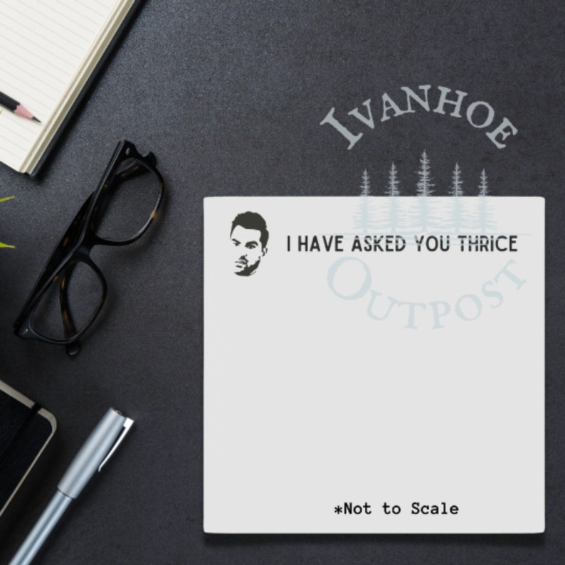 May include: White notepad with a black and white illustration of a man's face and the text "I have asked you thrice Outpost Ivanhoe *Not to Scale".