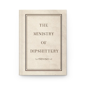 May include: A hardcover book with a cream-colored cover and a dark brown border. The text "THE MINISTRY OF DIPSHITTERY" is centered on the cover in a serif font. A decorative flourish is below the text.