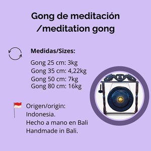 Puede incluir: Un gong de meditaci&oacute;n con una superficie azul oscuro y un centro dorado, montado en un marco de madera oscura. La imagen incluye texto en espa&ntilde;ol e ingl&eacute;s, con detalles de tama&ntilde;o y peso en cent&iacute;metros y kilogramos. Hecho a mano en Bali, Indonesia.