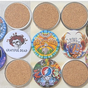 Puede incluir: Un conjunto de posavasos redondos con varios diseños, incluyendo el logo de Grateful Dead e imágenes psicodélicas. Los posavasos tienen una base de corcho y bordes metálicos, con gráficos coloridos. Diámetro aproximado de 10 cm.