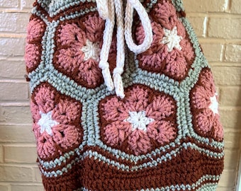 Bolsa de mano con cordón y flores africanas tejidas a crochet, hecha a mano, en tonos tostados, óxido y rosa empolvado.