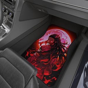 May include: Car floor mat featuring a vibrant anime-style illustration. The design showcases a character with long black hair, red eyes, and a red outfit, set against a backdrop of a red moon. The mat is black with a red and black design.