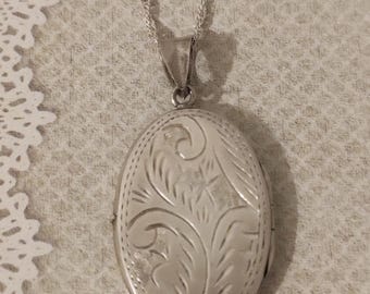 Medalhão vintage em prata, com gravura, em uma corrente fina e brilhante. Prata 925.