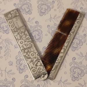 Antico portapettine pieghevole, in argento 800, molto decorativo.