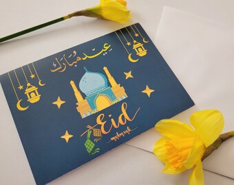 May include: A blue card with a gold mosque and stars. The card says "Eid Mubarak" in Arabic and "Eid Mubarak" in English.