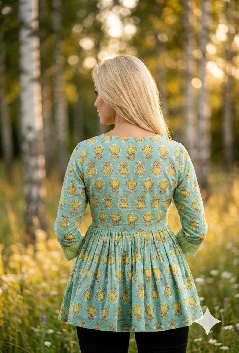 Teal green cotton print kurti for women with yellow floral block print design, handmade Indian ethnic tunic top with lace up neckline and tassel detail, soft breathable summer cotton kurta for casual daily wear, boho style printed kurti paired with black leggings, lightweight spring outfit for women, handcrafted floral cotton kurta for office wear and festive occasions, traditional Indian block print tunic with 3/4 sleeves, comfortable relaxed fit cotton kurti for vacation travel,