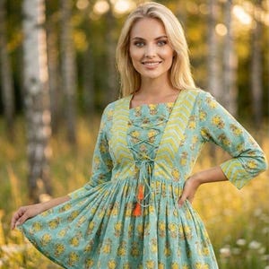 Teal green cotton print kurti for women with yellow floral block print design, handmade Indian ethnic tunic top with lace up neckline and tassel detail, soft breathable summer cotton kurta for casual daily wear, boho style printed kurti paired with black leggings, lightweight spring outfit for women, handcrafted floral cotton kurta for office wear and festive occasions, traditional Indian block print tunic with 3/4 sleeves, comfortable relaxed fit cotton kurti for vacation travel,