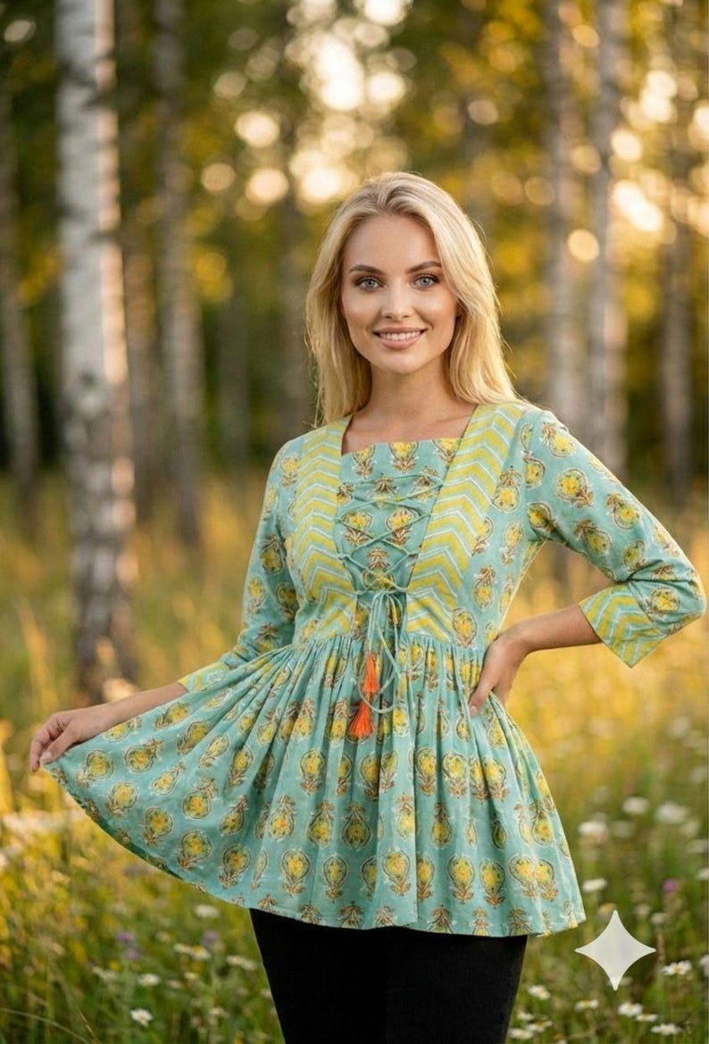 Teal green cotton print kurti for women with yellow floral block print design, handmade Indian ethnic tunic top with lace up neckline and tassel detail, soft breathable summer cotton kurta for casual daily wear, boho style printed kurti paired with black leggings, lightweight spring outfit for women, handcrafted floral cotton kurta for office wear and festive occasions, traditional Indian block print tunic with 3/4 sleeves, comfortable relaxed fit cotton kurti for vacation travel,
