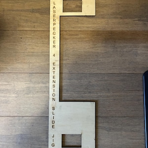 May include: A wooden jig for a laser engraver, labelled "Laserpecker 4 Extension Slide Jig". The jig has two rectangular cutouts labelled "Top" and "Bottom".