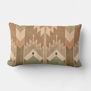 May include: Rectangular decorative pillow with a geometric pattern in shades of brown, beige, green, and peach. The design features repeating arrow-like shapes and diamond accents, creating a Southwestern or tribal aesthetic.