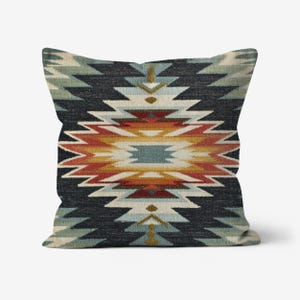 May include: Square throw pillow with a geometric pattern in shades of black, blue, red, orange, and cream. The design features a central diamond shape with zigzag edges, creating a Southwestern or tribal aesthetic.