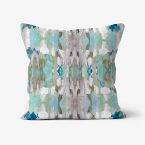 May include: A decorative throw pillow with a blue, green, and gray abstract pattern. The pillow has a white background and features a symmetrical design.
