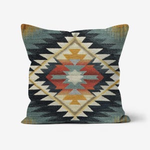 May include: Square decorative pillow with a geometric pattern in shades of blue, black, orange, yellow, and white. The pillow has a textured appearance and a southwestern design.