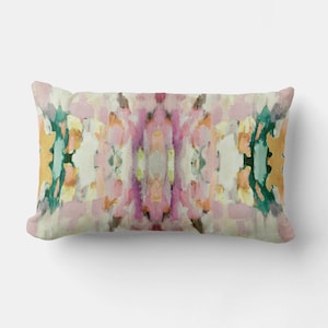 May include: A rectangular throw pillow with an abstract design featuring pink, green, yellow, and white watercolor-like patterns.