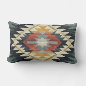 May include: Rectangular decorative pillow with a Southwestern geometric pattern. The pillow features a central diamond design in shades of red, yellow, blue, and cream, set against a dark teal background. The pillow is designed for home decor.