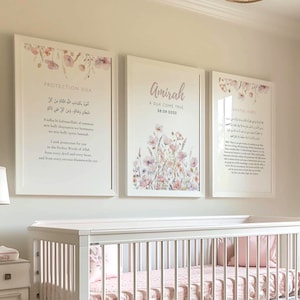 May include: A white cot with a pink and white bedding set. There are three framed prints on the wall behind the cot. The prints feature floral designs and Arabic text. A white armchair with a pink cushion sits in the corner of the room. A white footstool sits in front of the armchair. The room is decorated in a soft and feminine style.