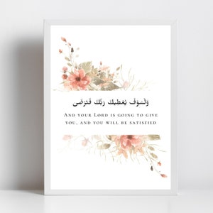 Pu&ograve; includere: Una stampa incorniciata bianca con un motivo floreale in tonalit&agrave; rosa e verde. La stampa presenta una citazione araba che si traduce in "E il tuo Signore ti dar&agrave;, e sarai soddisfatto."