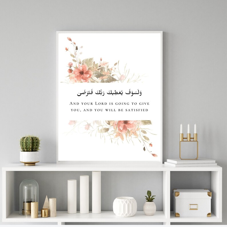 Pu&ograve; includere: Una stampa su tela bianca con un design floreale e il testo "And your Lord is going to give you, and you will be satisfied" in inglese e arabo.