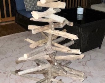 Peut inclure: Une sculpture décorative en forme d'arbre, fabriquée à partir de bois flotté naturel. L'arbre présente un design en couches avec des branches s'étendant vers l'extérieur, créant une esthétique unique et rustique. La sculpture mesure environ 91 cm de haut.