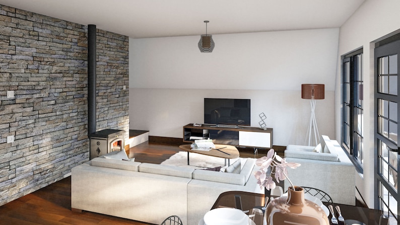 May include: A modern living room with a white sectional sofa, a coffee table, a television, a wood-burning stove, and a large window. The room has a light and airy feel with a stone wall and wood floors.
