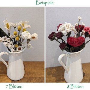 Op de afbeelding: Twee gehaakte bloemstukken in witte keramische kannen. De eerste opstelling heeft witte bloemen met gele centra en groene bladeren. De tweede opstelling heeft roze, witte en rode gehaakte bloemen met groene bladeren. De tekst "7 Bl&uuml;ten" staat onder de eerste opstelling en "8 Bl&uuml;ten" staat onder de tweede opstelling.