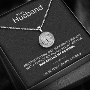 May include: A silver necklace with a compass pendant on a black velvet box. The box has a message that reads "To My Husband, Meeting you was fate, becoming your wife was a choice but falling in love with you was beyond my control. I love you, forever & always."