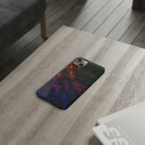 May include: A black phone case with a geometric pattern of colorful lines. The lines are red, orange, yellow, green, blue, and purple.