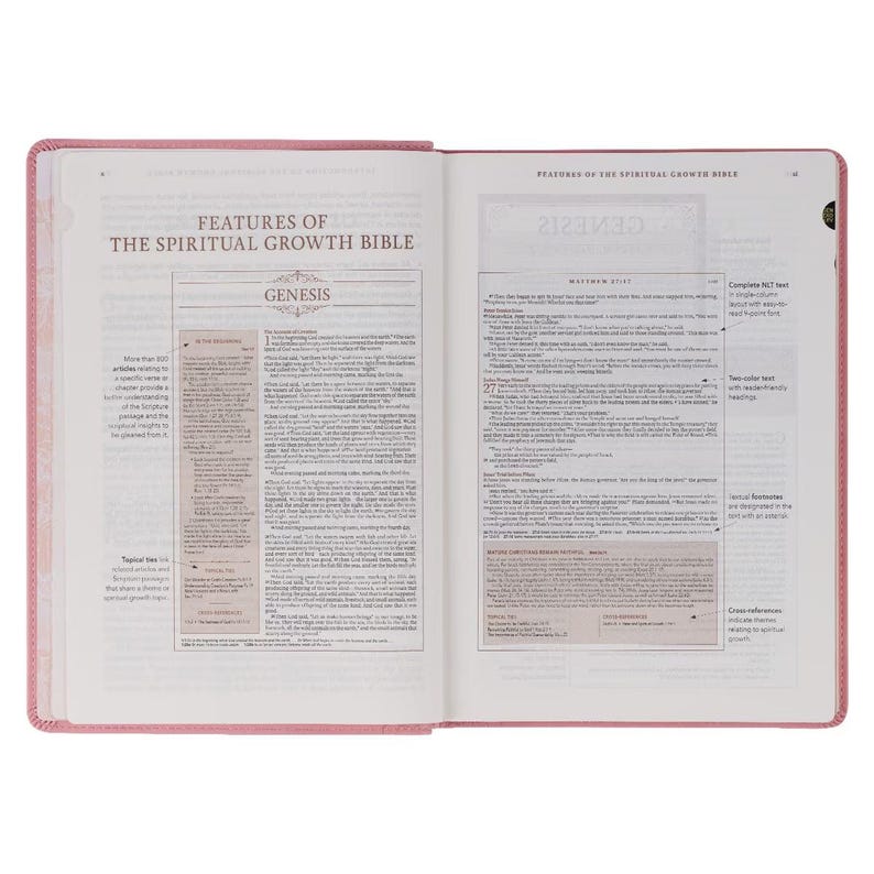 May include: Open view of a pink Bible with the title "Features of the Spiritual Growth Bible" visible. The pages are open to the Genesis section, with detailed text and annotations. The Bible has a pink cover and a ribbon bookmark.