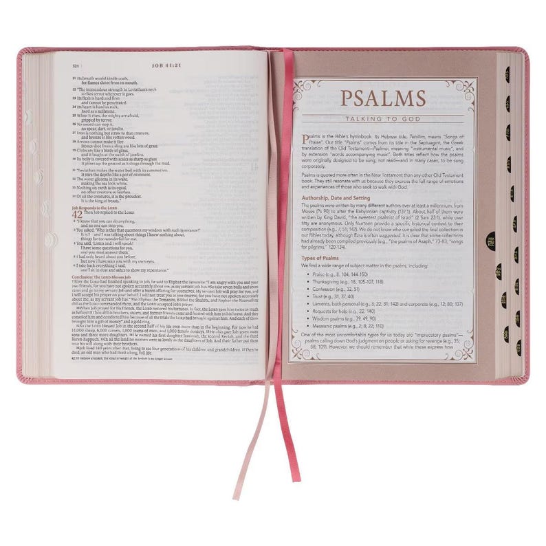 May include: Open Bible with pink cover and matching ribbon bookmark. The pages are filled with text, and a section on Psalms is visible. The book is open, displaying the text and design of the pages.