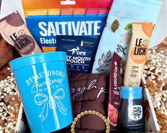 May include: A gift box containing a blue plastic cup with Dysautonomia Awareness Month text, a Saltivate electrolyte pouch, two Le Lick electrolyte lollipops, a blue patterned sock, a dark brown quilted pouch, a Liquid I.V. packet, Salt stick, and a gold bead bracelet.