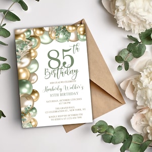 Puede incluir: Una invitación para una celebración de 85 cumpleaños. El diseño presenta un fondo blanco con globos dorados y verdes, hojas de eucalipto y flores blancas. El texto de la invitación incluye el nombre, la fecha, la hora y el lugar de la celebración.