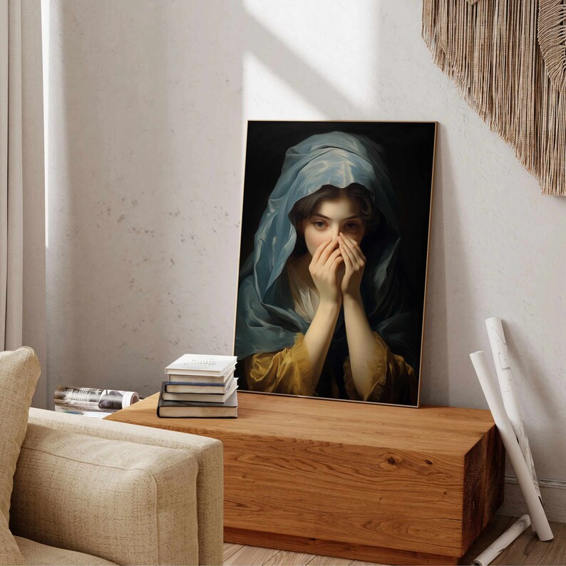 May include: A painting of a woman with her hands covering her face. She is wearing a blue and gold robe and has long dark hair. The painting is framed in a gold frame.