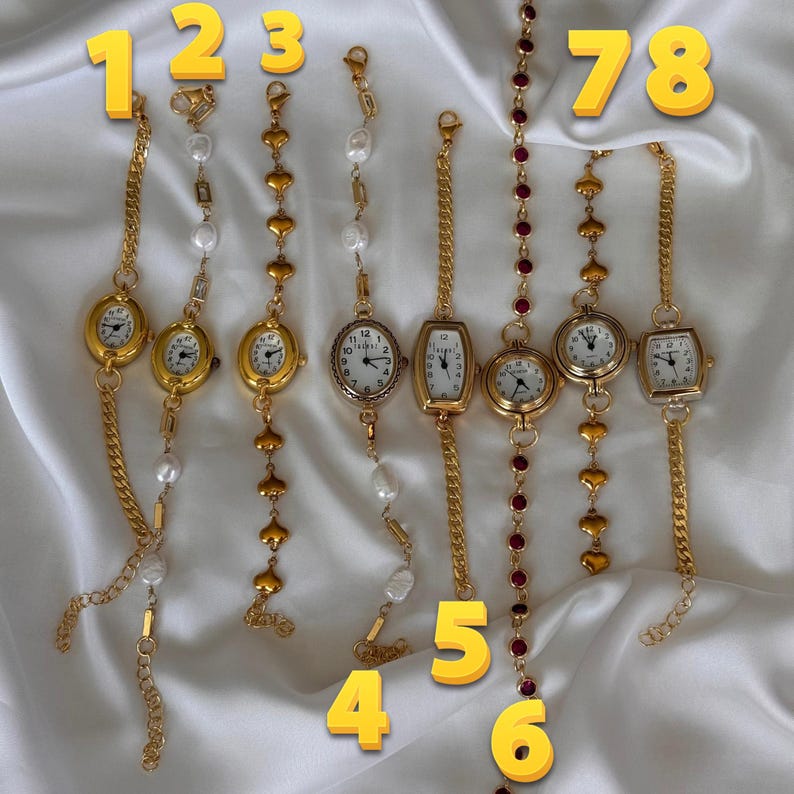 K&ouml;nnte beinhalten: Acht goldfarbene Armbanduhren mit unterschiedlichen Designs. Einige haben wei&szlig;e Zifferbl&auml;tter mit schwarzen Ziffern, andere dekorative Ketten, Perlen und herzf&ouml;rmige Akzente. Die Uhren sind auf einem wei&szlig;en, seidigen Hintergrund pr&auml;sentiert.