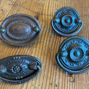 May include: A white ceramic mug with a black handle and the text "But First, Coffee" in a handwritten style. The mug is on a white surface. The mug is approximately 4 inches tall.