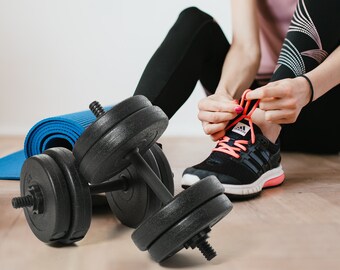 May include: A set of black dumbbell weights with blue rubber grips. The weights are lying on a blue yoga mat.
