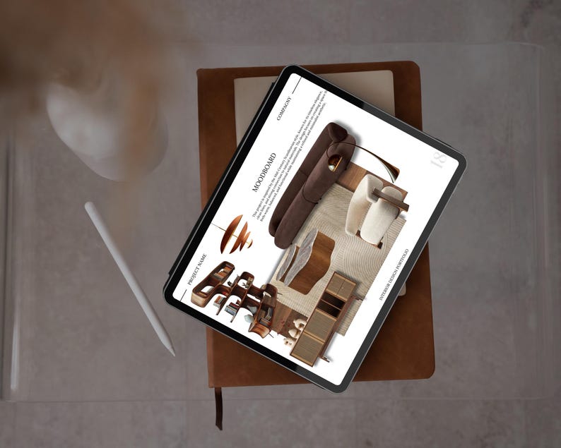May include: A digital tablet displaying a mood board for an interior design portfolio. The tablet rests on a brown leather-bound notebook, with a white stylus and a white object in the background. The mood board features furniture and design elements.
