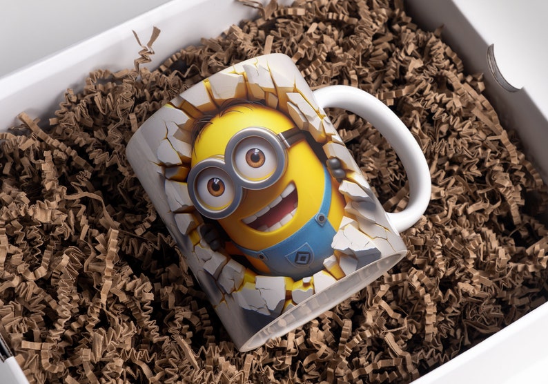 May include: White ceramic mug with a 3D image of a yellow Minion character breaking through a wall. The Minion is wearing blue overalls and goggles and has a big smile.