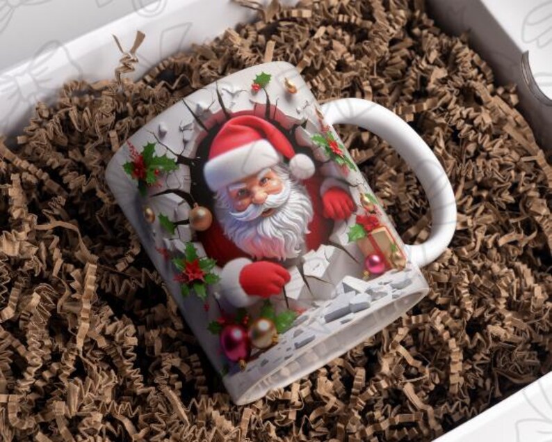 May include: White ceramic mug with a Christmas-themed design featuring Santa Claus breaking through a wall with red and green accents. The mug has a handle and is filled with brown packing peanuts.