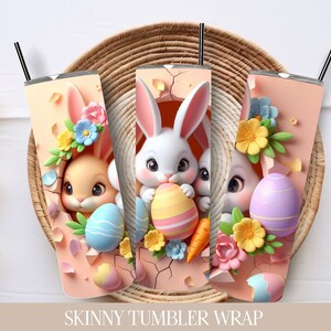 Puede incluir: Tres envolturas para vasos delgados con conejos de Pascua asomando por huevos rotos. Las envolturas son rosas con huevos de colores pastel, flores y zanahorias. El texto "SKINNY TUMBLER WRAP" est&aacute; impreso debajo de las im&aacute;genes. El texto "STRAIGHT 9.35 X 8.2" est&aacute; impreso en la esquina inferior derecha.