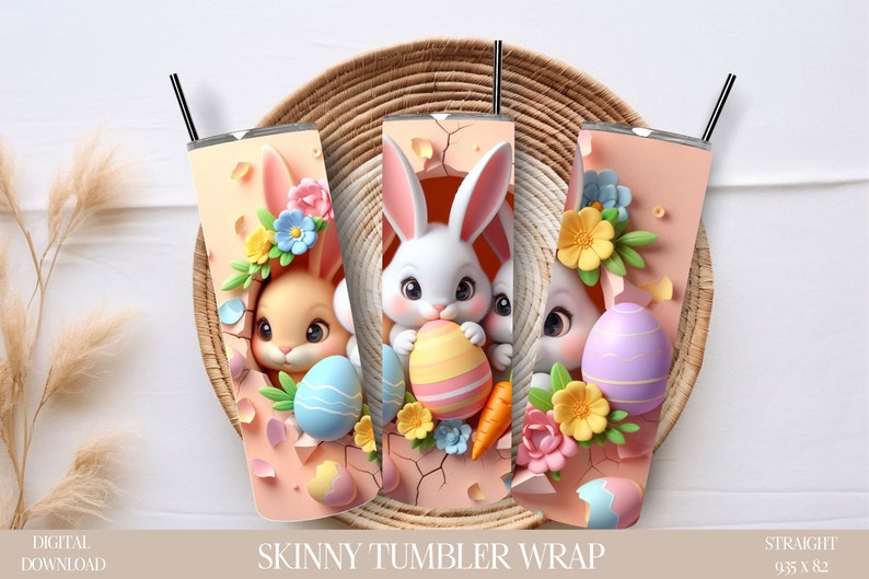 Puede incluir: Tres envolturas para vasos delgados con conejos de Pascua asomando por huevos rotos. Las envolturas son rosas con huevos de colores pastel, flores y zanahorias. El texto "SKINNY TUMBLER WRAP" est&aacute; impreso debajo de las im&aacute;genes. El texto "STRAIGHT 9.35 X 8.2" est&aacute; impreso en la esquina inferior derecha.