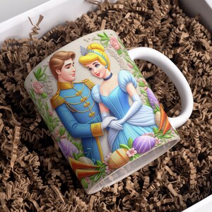 May include: A white ceramic mug with a colorful illustration of Prince Charming and Cinderella. The mug features a floral design with pastel-colored Easter eggs.