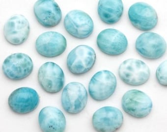 Könnte beinhalten: Eine Sammlung oval geformter, polierter Edelsteine in verschiedenen Blau- und Weißtönen. Die Steine haben ein marmoriertes Aussehen mit Wirbeln und Mustern. Die Edelsteine werden wahrscheinlich für die Schmuckherstellung oder das Basteln verwendet.