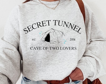May include: Gray sweatshirt with the text "SECRET TUNNEL est. 2006 CAVE OF TWO LOVERS" and a black and white illustration of a cave entrance.