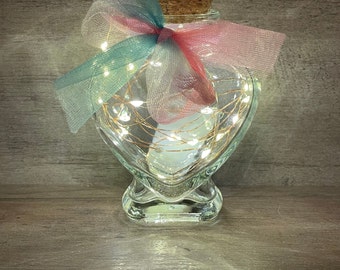 Super cute small heart shaped glass jar with cork lid and copper wire firefly lighting.  Classy wedding favor idea.  Valentine’s Day gift!!!
