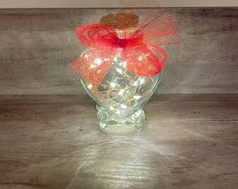 Mini heart shaped glass jar with cork lid and firefly lighting.  Cute gift for Valentine’s Day.  Classy wedding favor idea.