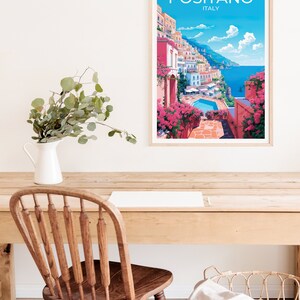 Może przedstawiać: Ramka z plakatem przedstawiającym kolorową ilustrację Positano we Włoszech. Plakat przedstawia widok na kolorowe budynki miasta, basen i Morze Śr&oacute;dziemne. Tekst "Positano, Włochy" jest wydrukowany na g&oacute;rze plakatu na biało.