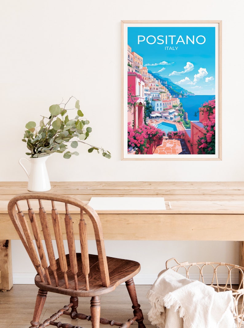 Może przedstawiać: Ramka z plakatem przedstawiającym kolorową ilustrację Positano we Włoszech. Plakat przedstawia widok na kolorowe budynki miasta, basen i Morze Śr&oacute;dziemne. Tekst "Positano, Włochy" jest wydrukowany na g&oacute;rze plakatu na biało.