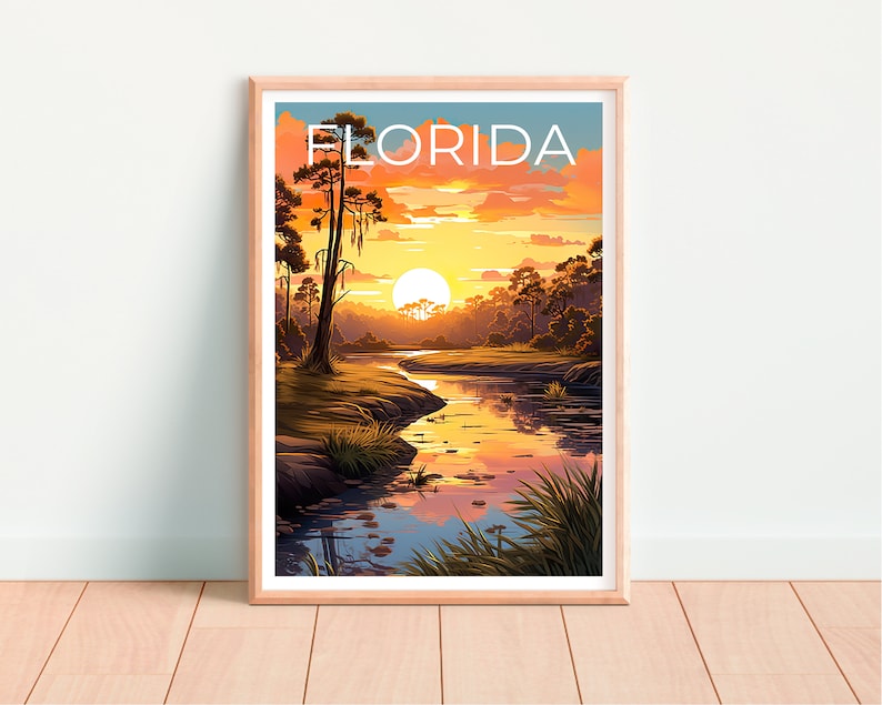 K&ouml;nnte beinhalten: Ein gerahmter Druck mit einer Sonnenuntergangsszene &uuml;ber einem Fluss in Florida. Der Druck zeigt einen leuchtend orangefarbenen und gelben Sonnenuntergang mit einer einzigen, gro&szlig;en, wei&szlig;en Sonne am Himmel. Der Fluss ist hellblau und auf beiden Seiten des Flusses befinden sich B&auml;ume. Der Text "FLORIDA" ist oben auf dem Druck in Wei&szlig; gedruckt.