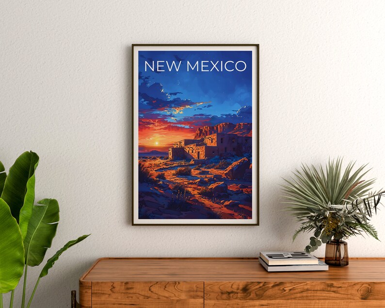 May include: A vintage travel poster featuring a sunset over a desert landscape with a pueblo-style building in the foreground. The poster is framed in a dark wood frame and has the text "NEW MEXICO" at the top.
